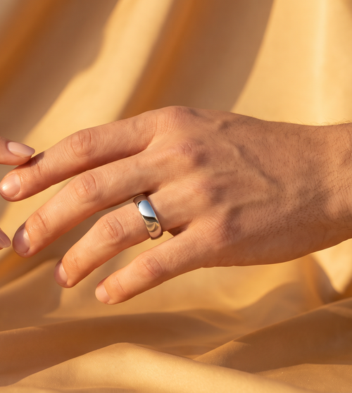 Mudrika Ring in silver, hand reaching toward its gold counterpart